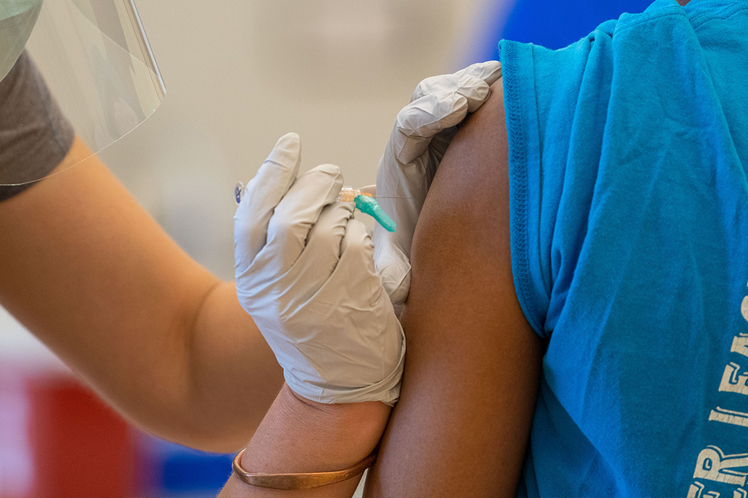 A medical professional gives a patient a flu shot.