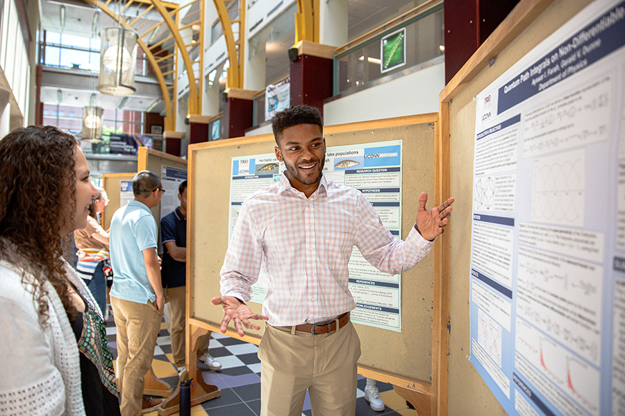 Ayssar Farah, a McNair Scholar and physics major, presents research in the Rowe Building.
