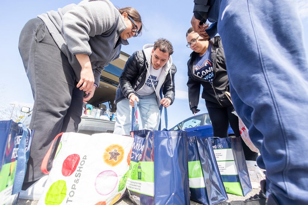 Students look through bags outside while working on an outreach projects