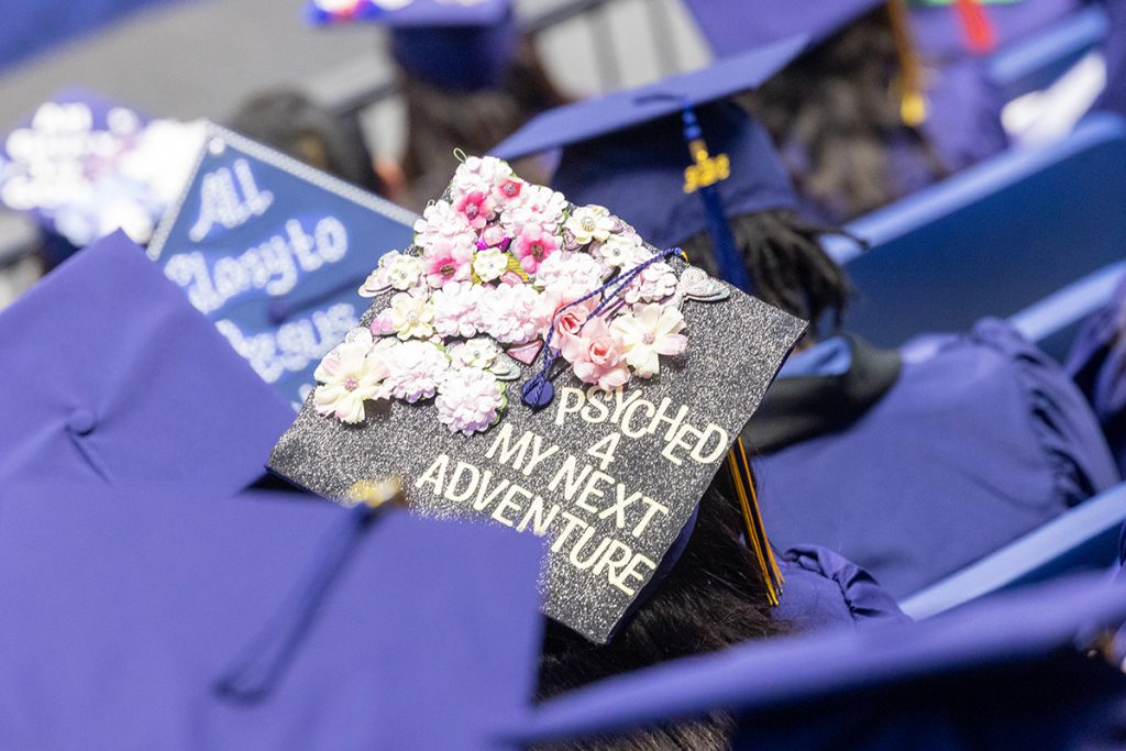 A decorated graduation cap at commencement that reads "psyched 4 my next adventure."