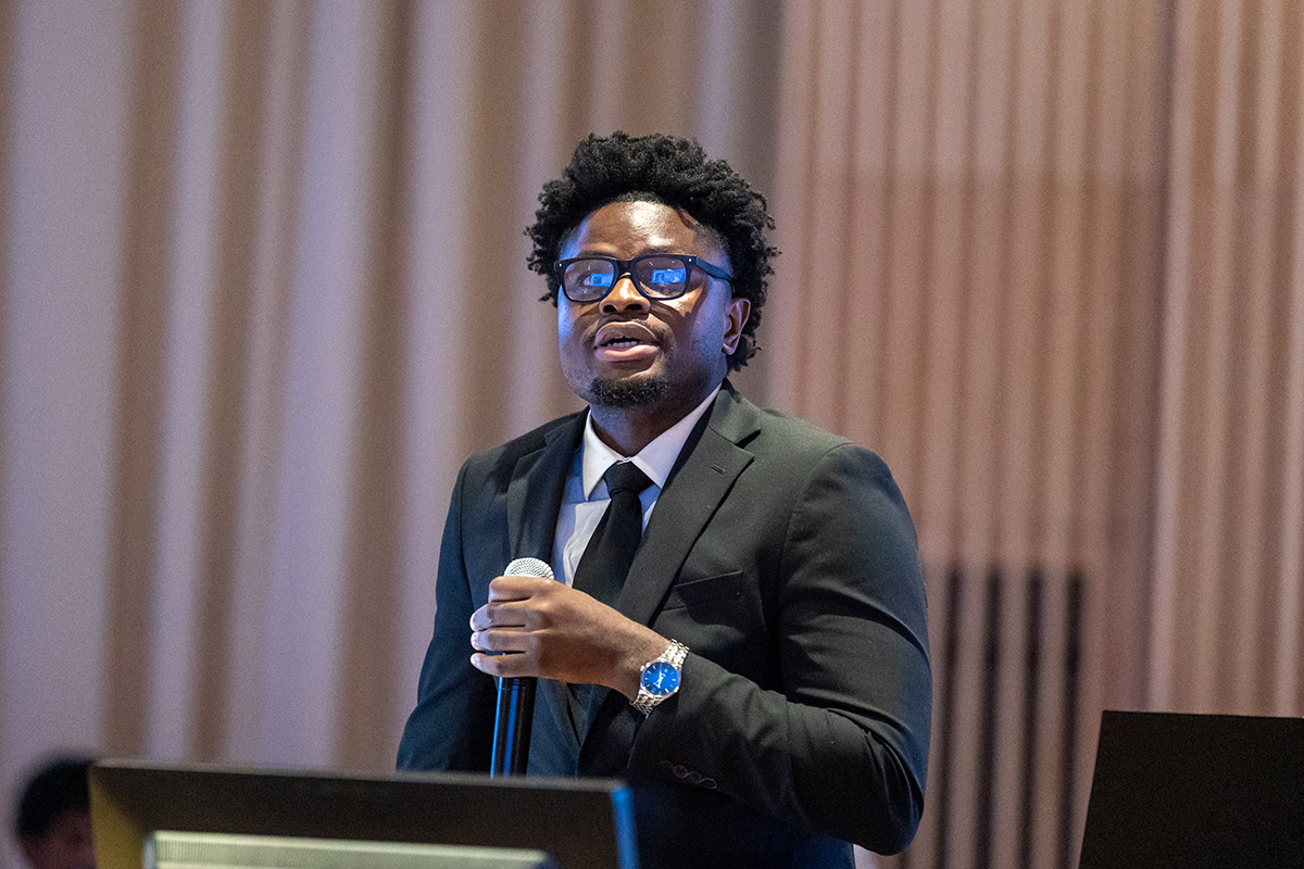 A student presents a project in the Rotunda of the Academic Building at UConn Health during Summer Research Day.