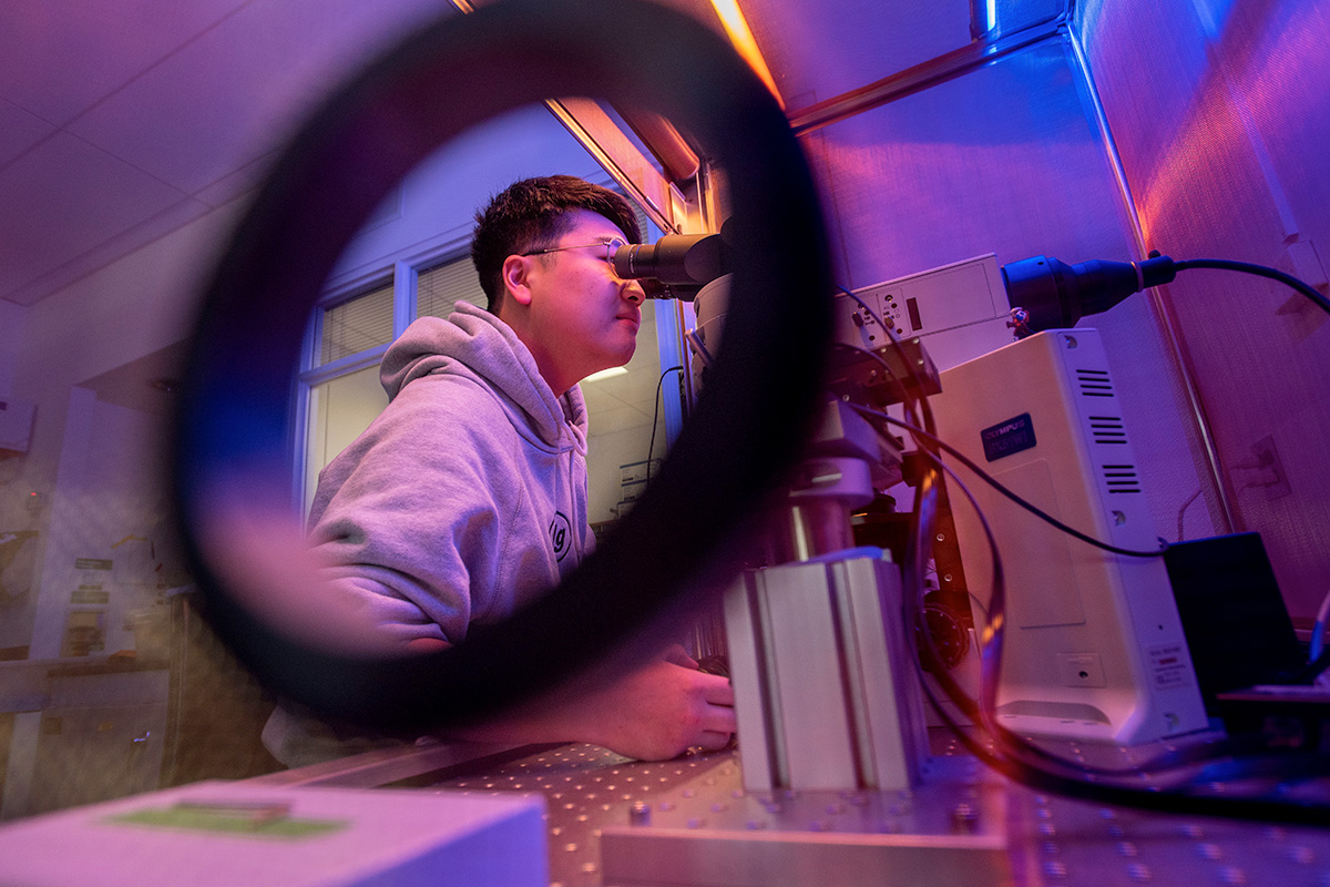 A graduate student uses an electrophysiology rig to conduct research.
