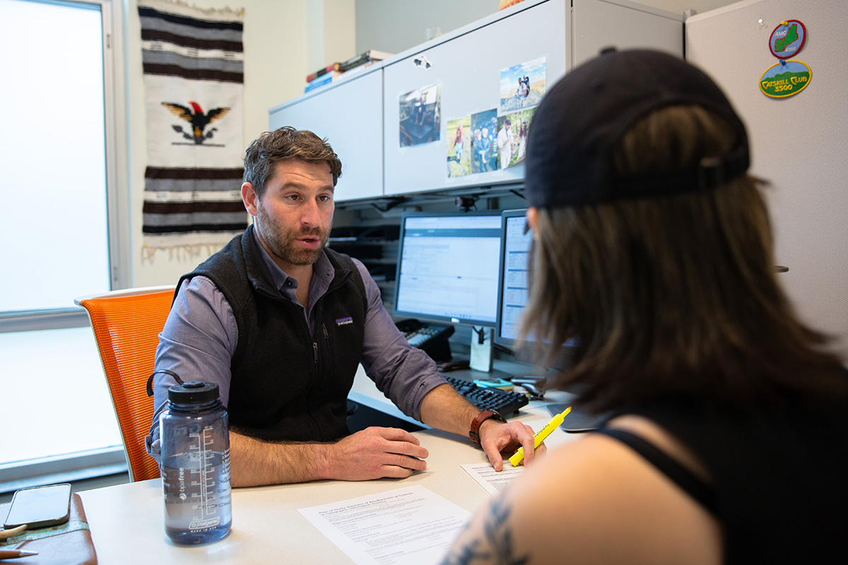An advisor meets with a student in their office.