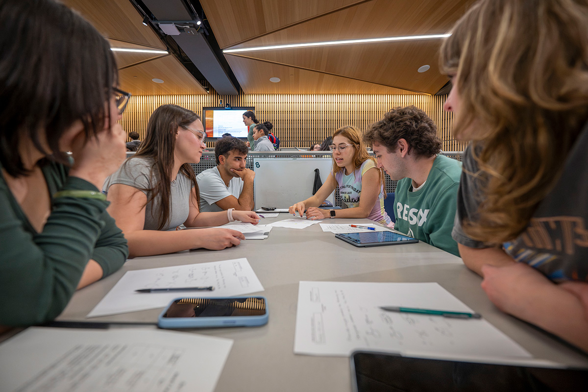 A group of five students work on a project together in class. 