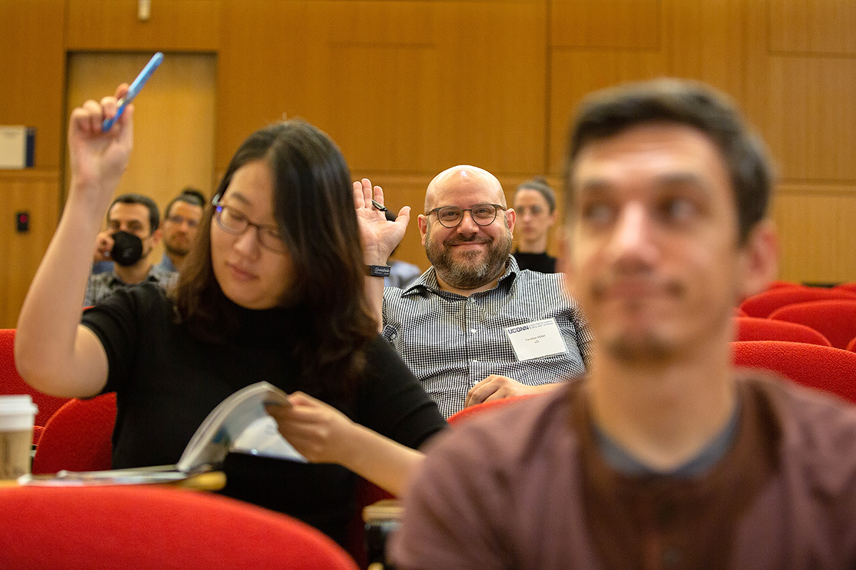 Faculty participating in a new staff orientation raise their hands while answering a question.