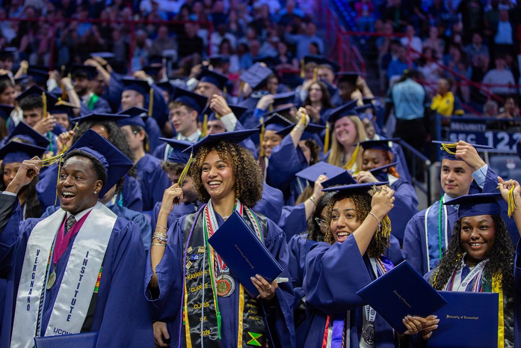 Students turn their tassels at graduation in Gampel Pavilion.