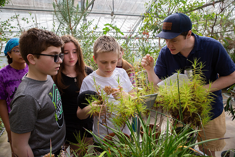 A representative of the UConn Botanical Conservatory speaks to young students.